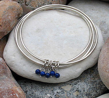 Three sterling silver bangles attached with blue lapis